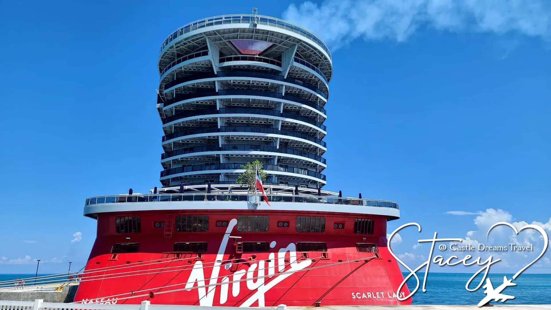 Scarlet Lady, Virgin Voyages' red-hulled cruise ship, docked under a clear blue sky
