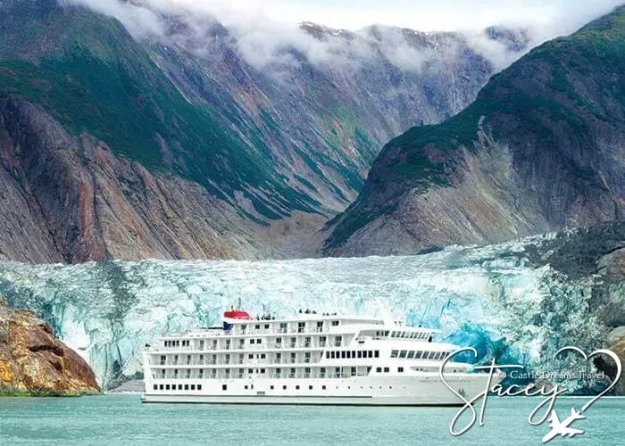 Small cruise ship dwarfed by a tidewater glacier in Alaska
