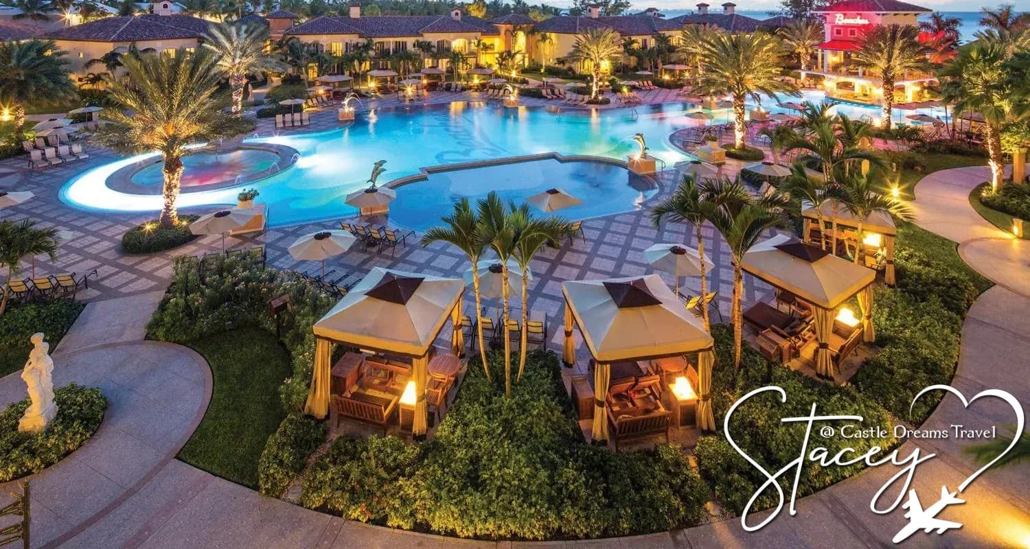 Pool, palm trees, and lit cabanas at dusk at a Beaches all-inclusive resort