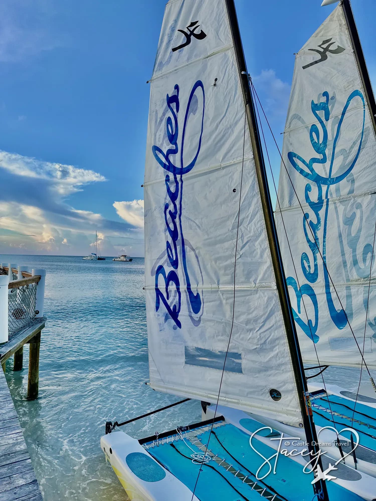 Beaches-branded catamaran sails rigged on the beach beside calm shallow water