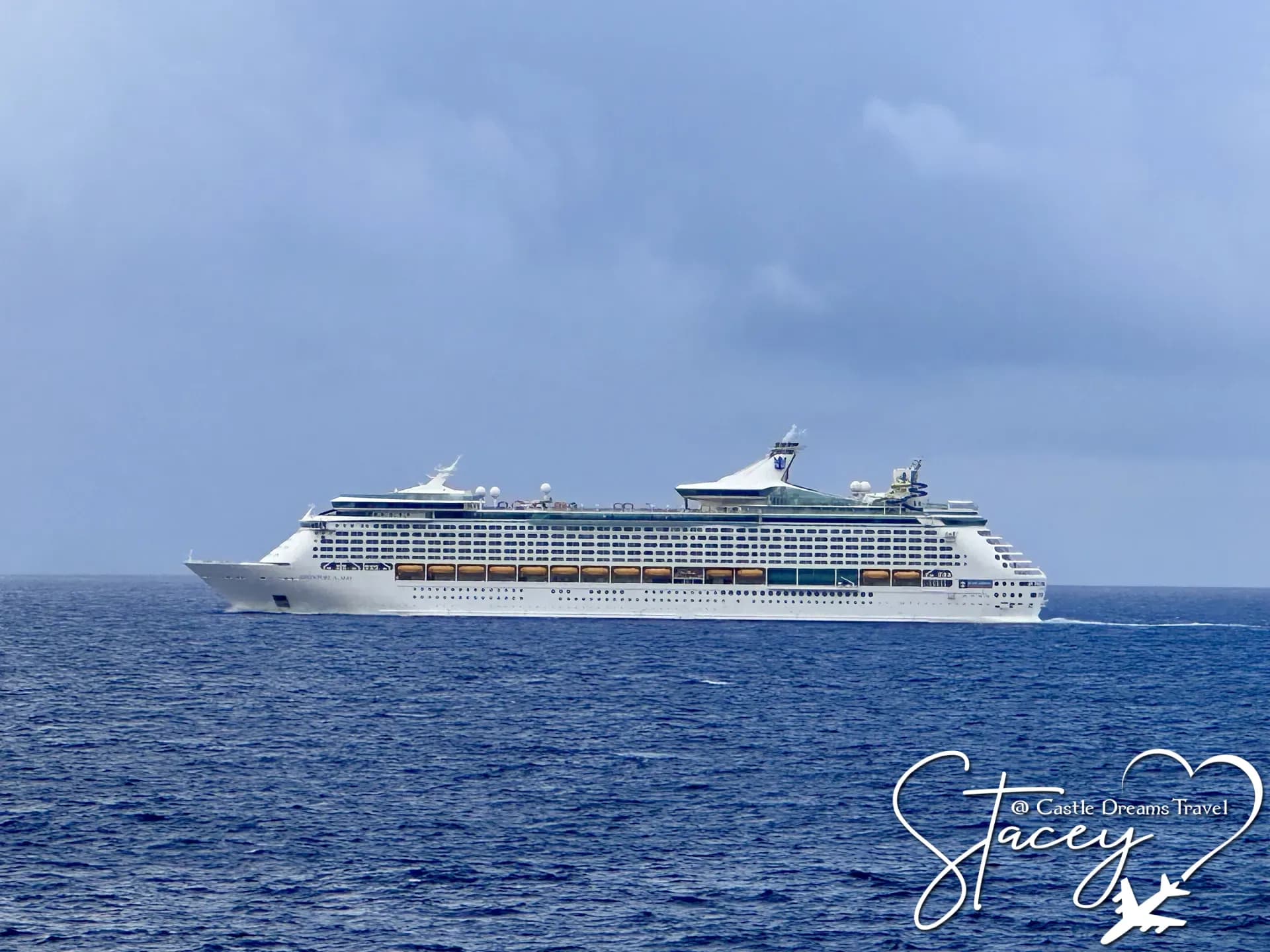 A Royal Caribbean ship sailing on open blue ocean under a clear sky