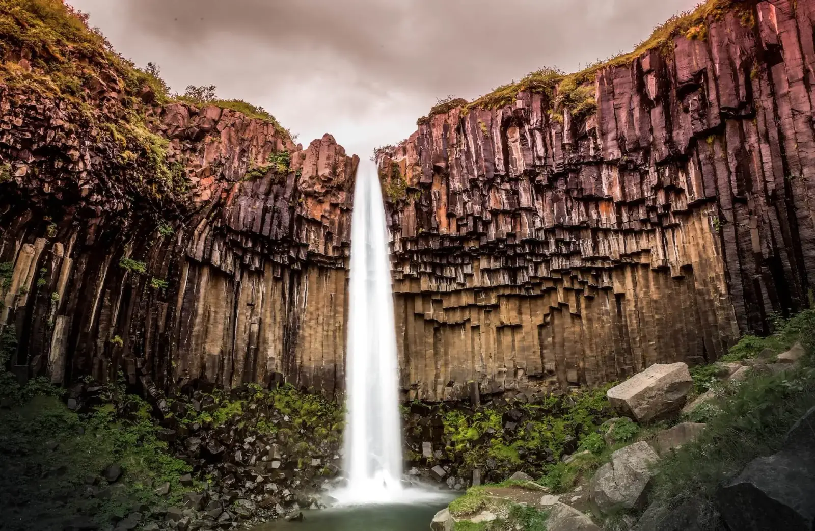 A powerful waterfall pouring over volcanic cliffs in Iceland