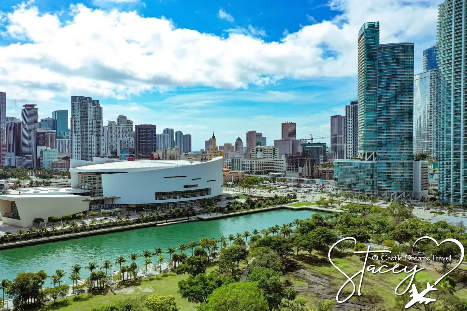 Downtown Miami skyline with waterfront park and palm-lined canal