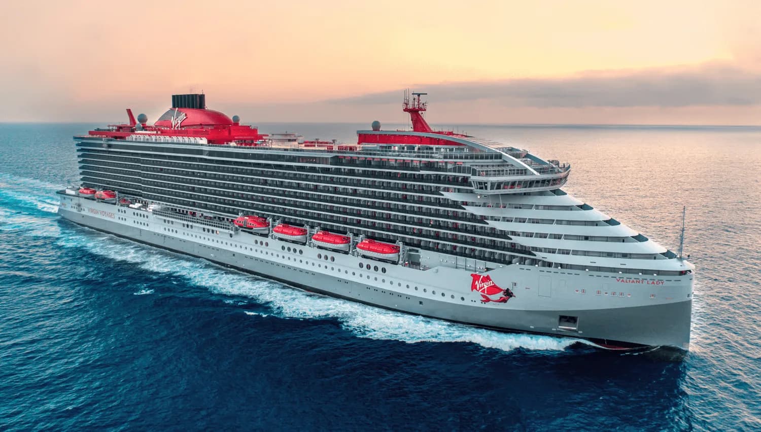 Virgin Voyages' Valiant Lady at sea at sunset