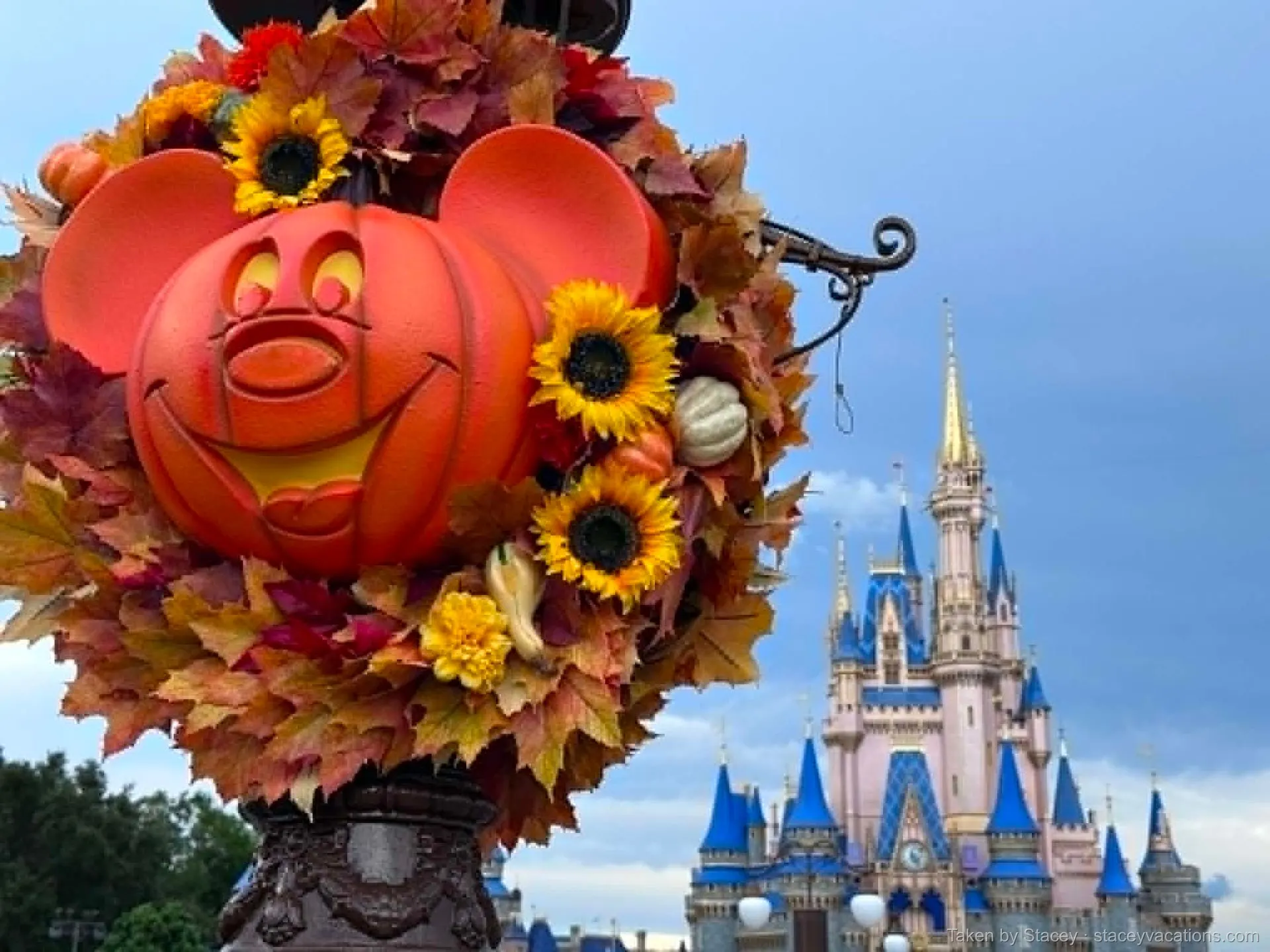 Mickey-shaped pumpkin wreath on a Main Street lamppost with Cinderella Castle behind on a fall day — photo by Stacey