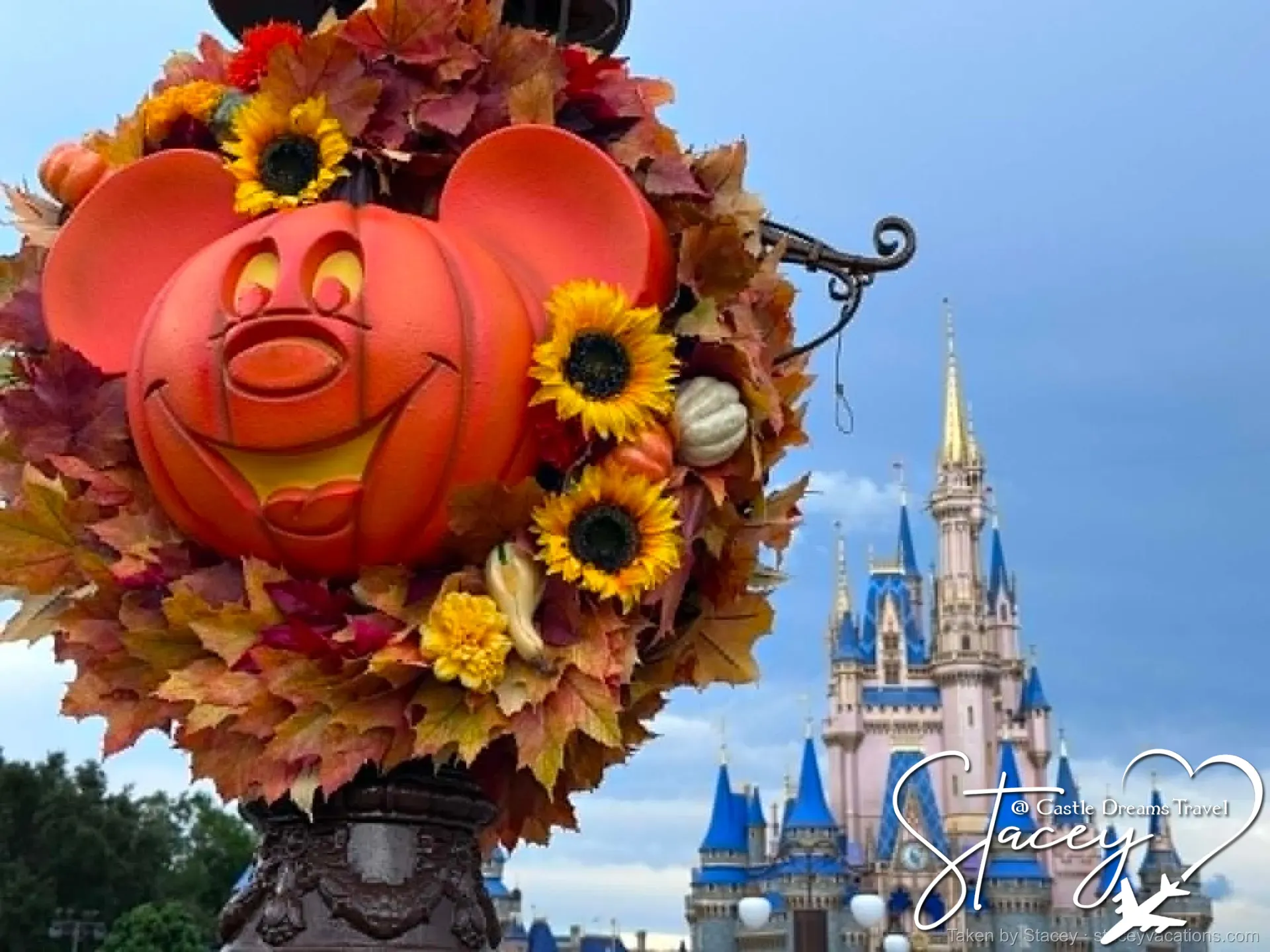 Mickey-shaped pumpkin wreath on a Main Street lamppost with Cinderella Castle behind on a fall day — photo by Stacey
