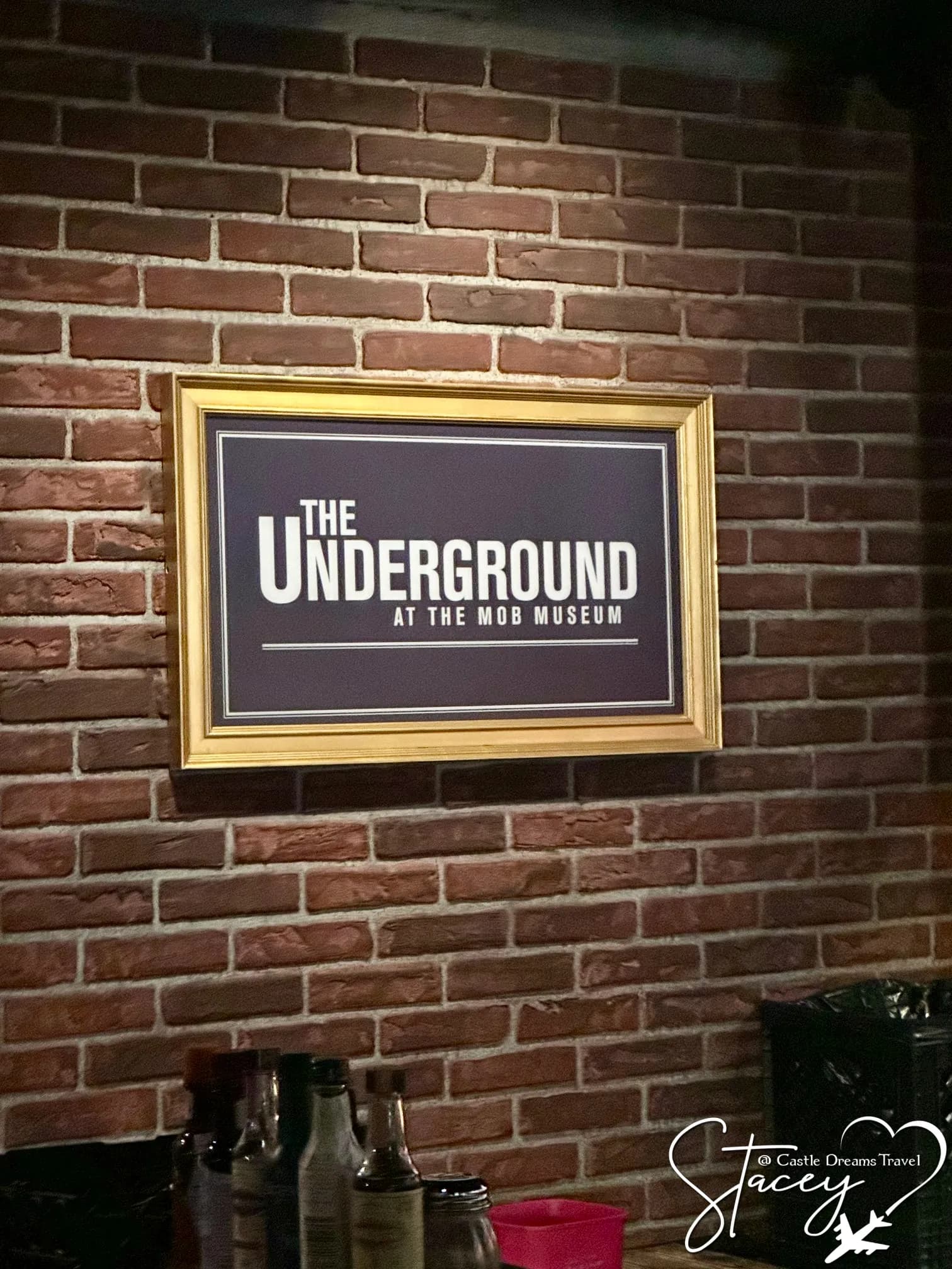 A framed sign reading The Underground at the Mob Museum mounted on a brick wall