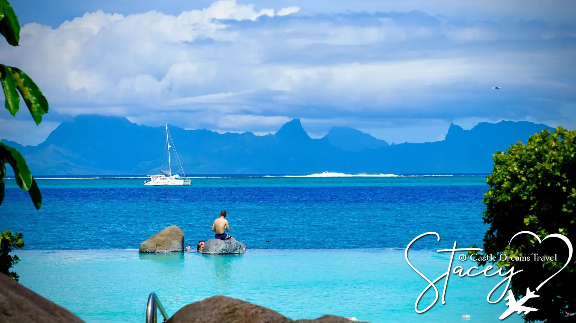 Catamaran on a turquoise lagoon in Tahiti with mountainous islands on the horizon