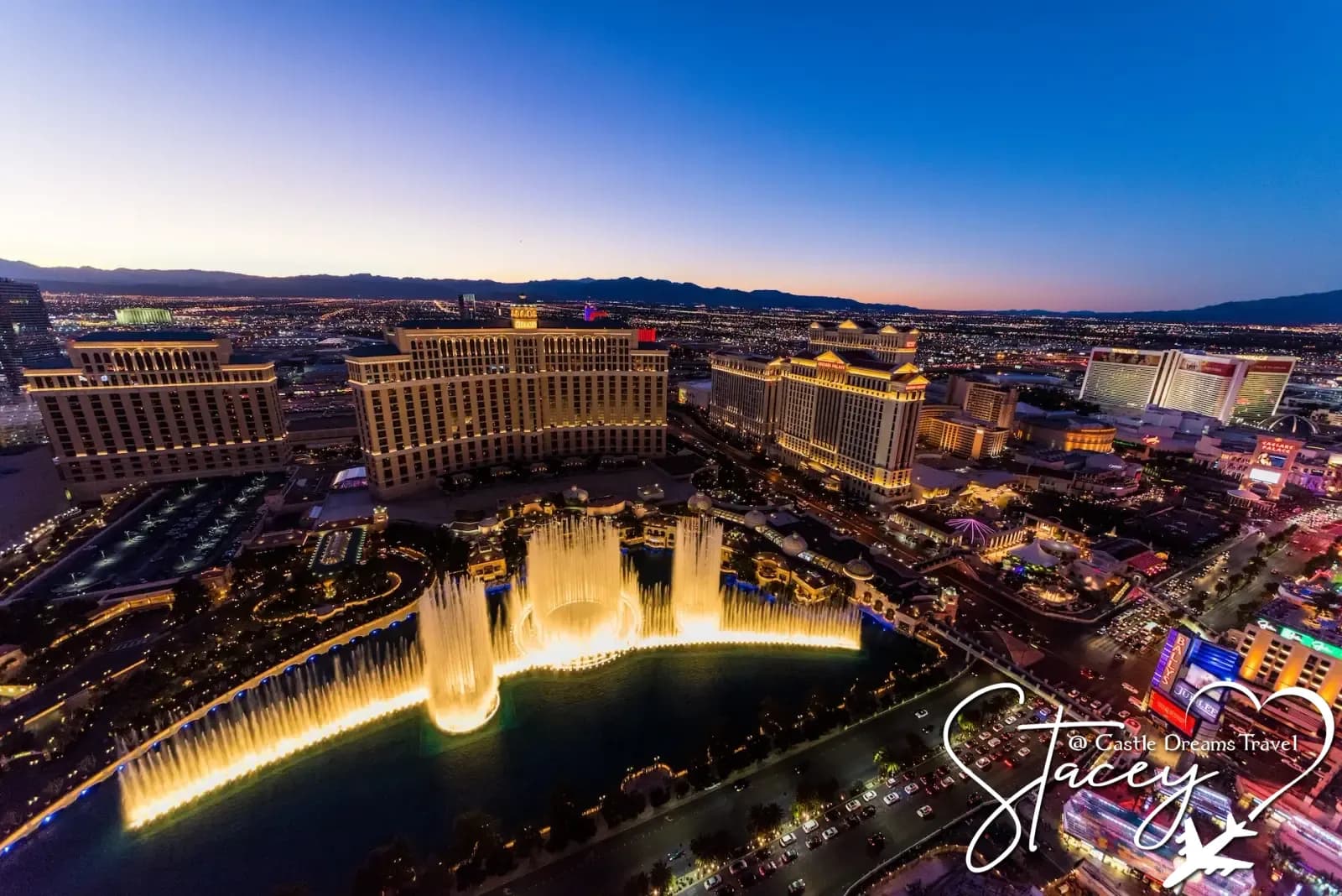 The Bellagio Fountains lit up at dusk with the Las Vegas Strip stretching into the distance
