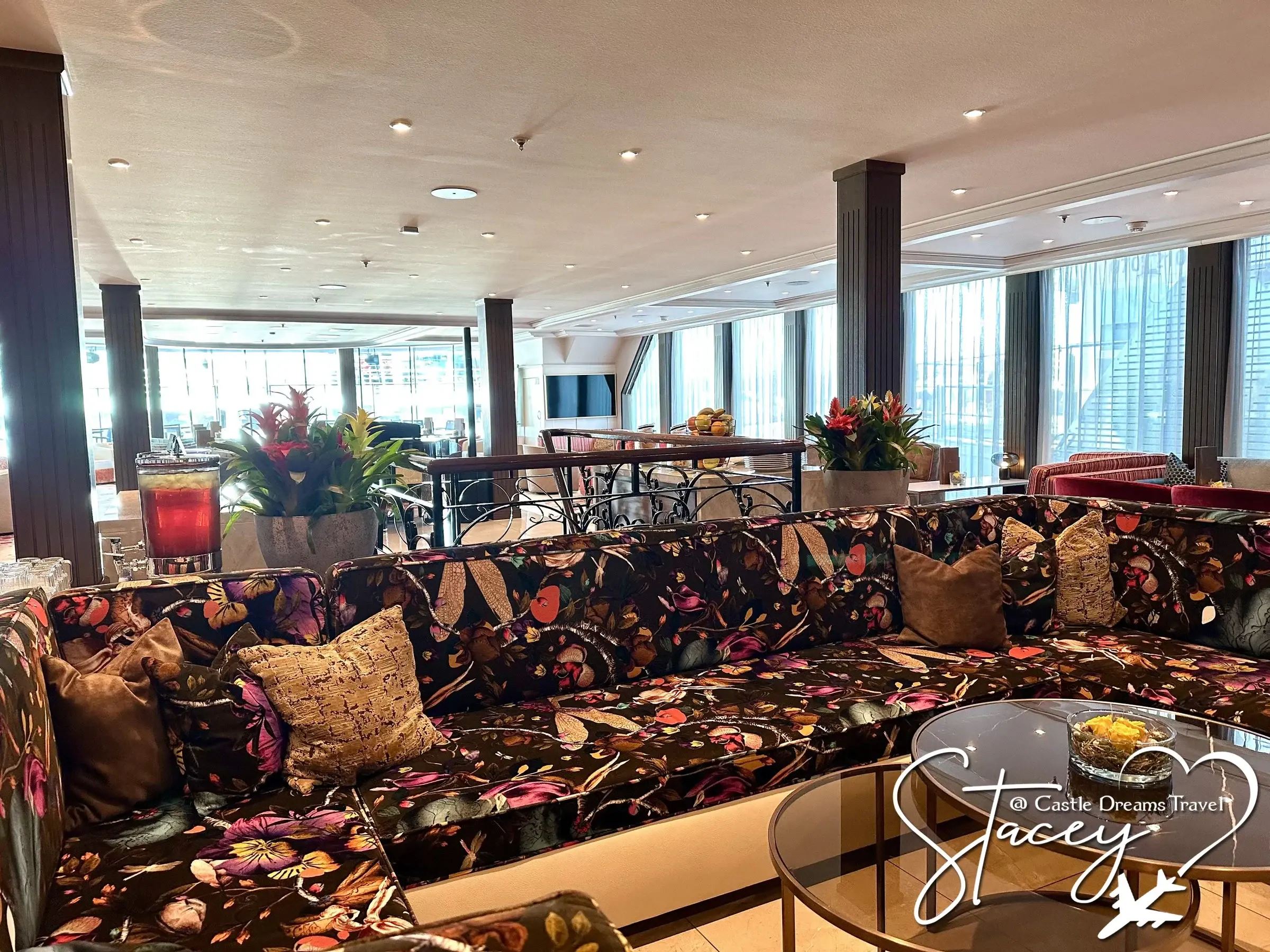The main lounge aboard AmaWaterways' AmaMagna, floral upholstery and floor-to-ceiling river windows