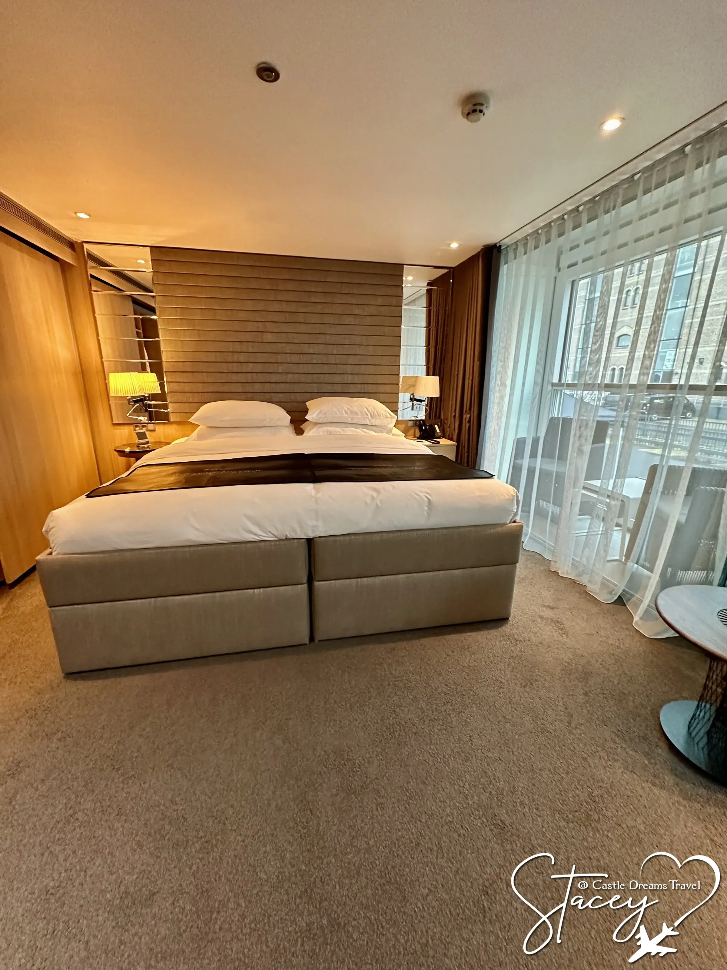A Scenic suite with twin beds facing a full-width balcony window